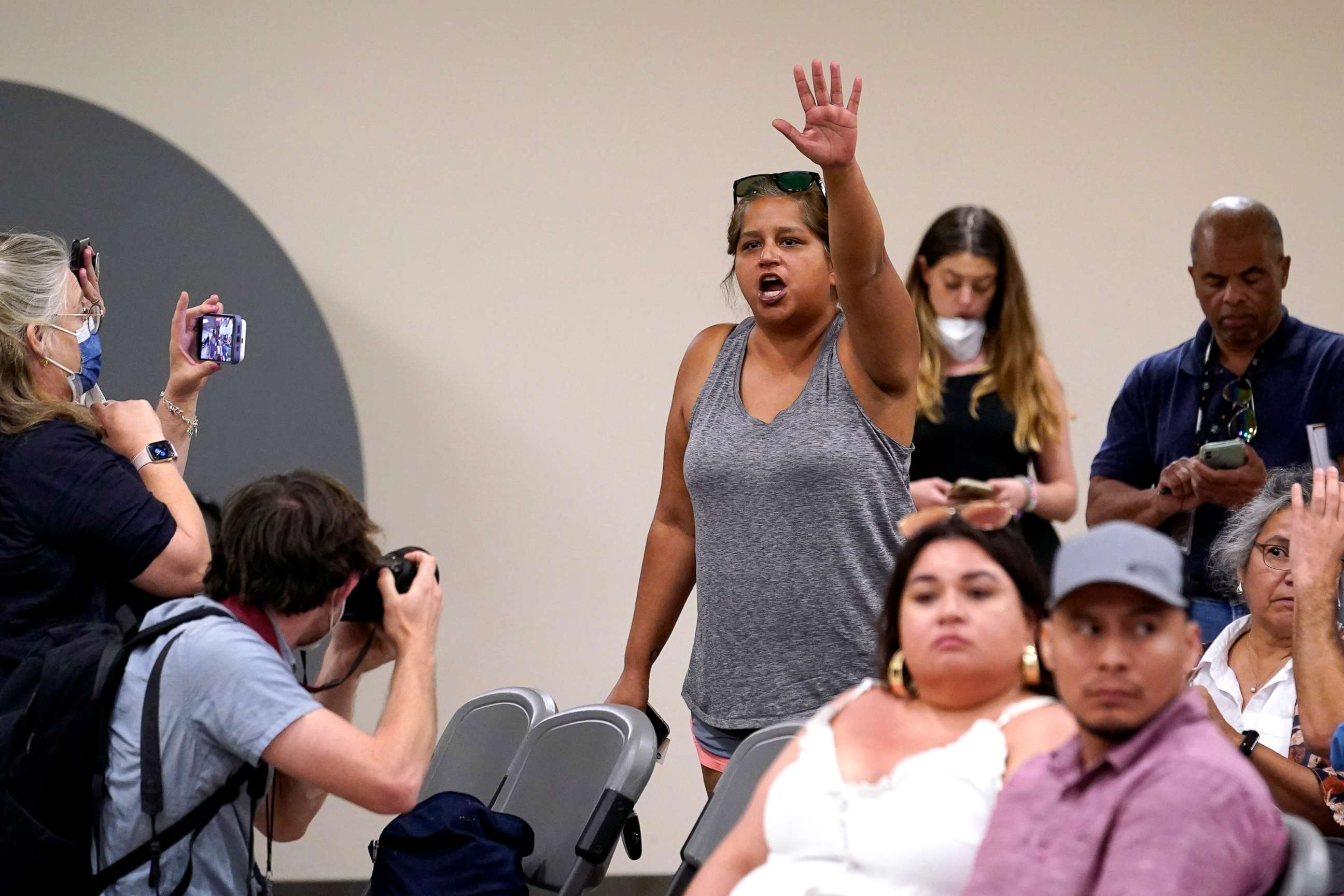 PHOTO: Tina Quintanilla-Taylor raises her hand as she tries to ask a question of the Texas House investigative committee at a news conference after they released its full report on the shootings at Robb Elementary School, July 17, 2022, in Uvalde, Texas.