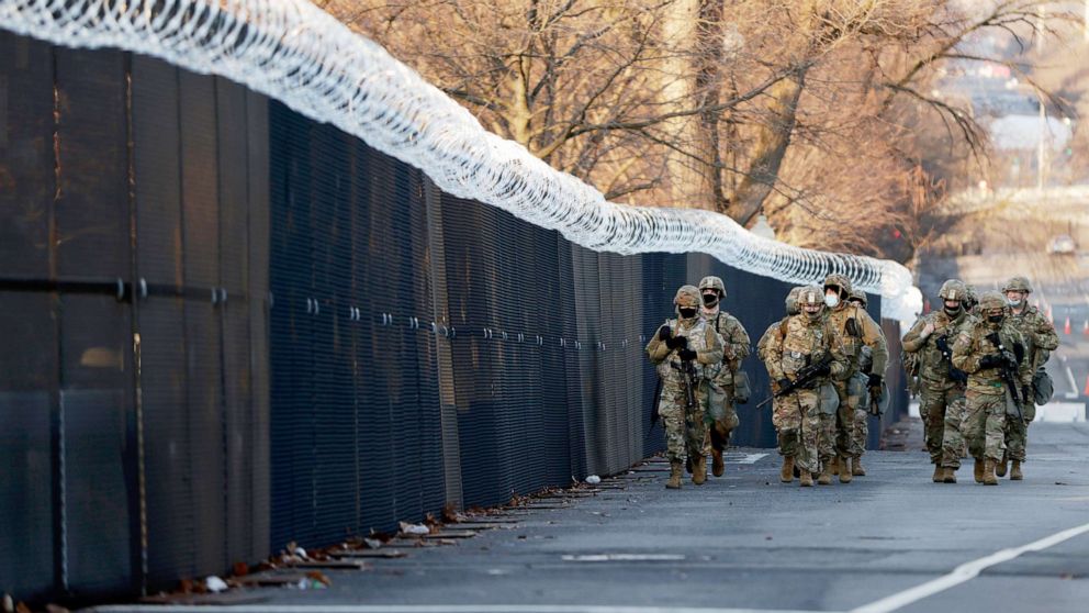 PHOTO: A group of Virginia National Guard patrol around the razor wire fence surrounding the U.S. Capitol grounds in Washington, Jan. 16, 2021. 