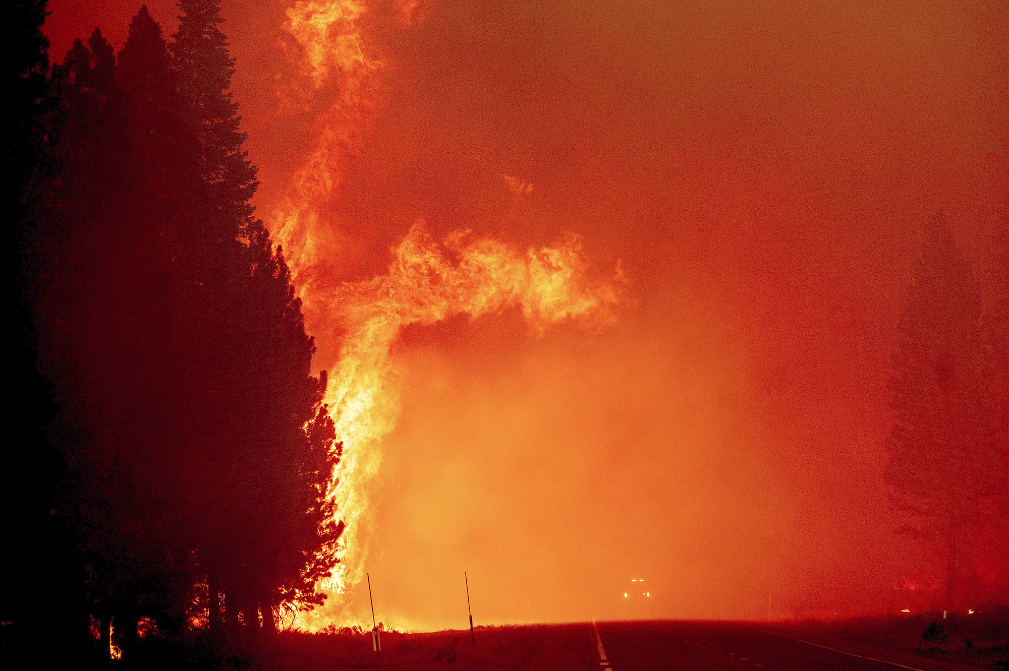 PHOTO: Flames leap above a fire vehicle on Highway 89 as the Dixie Fire burns towards Chester, Calif., Aug. 4, 2021.