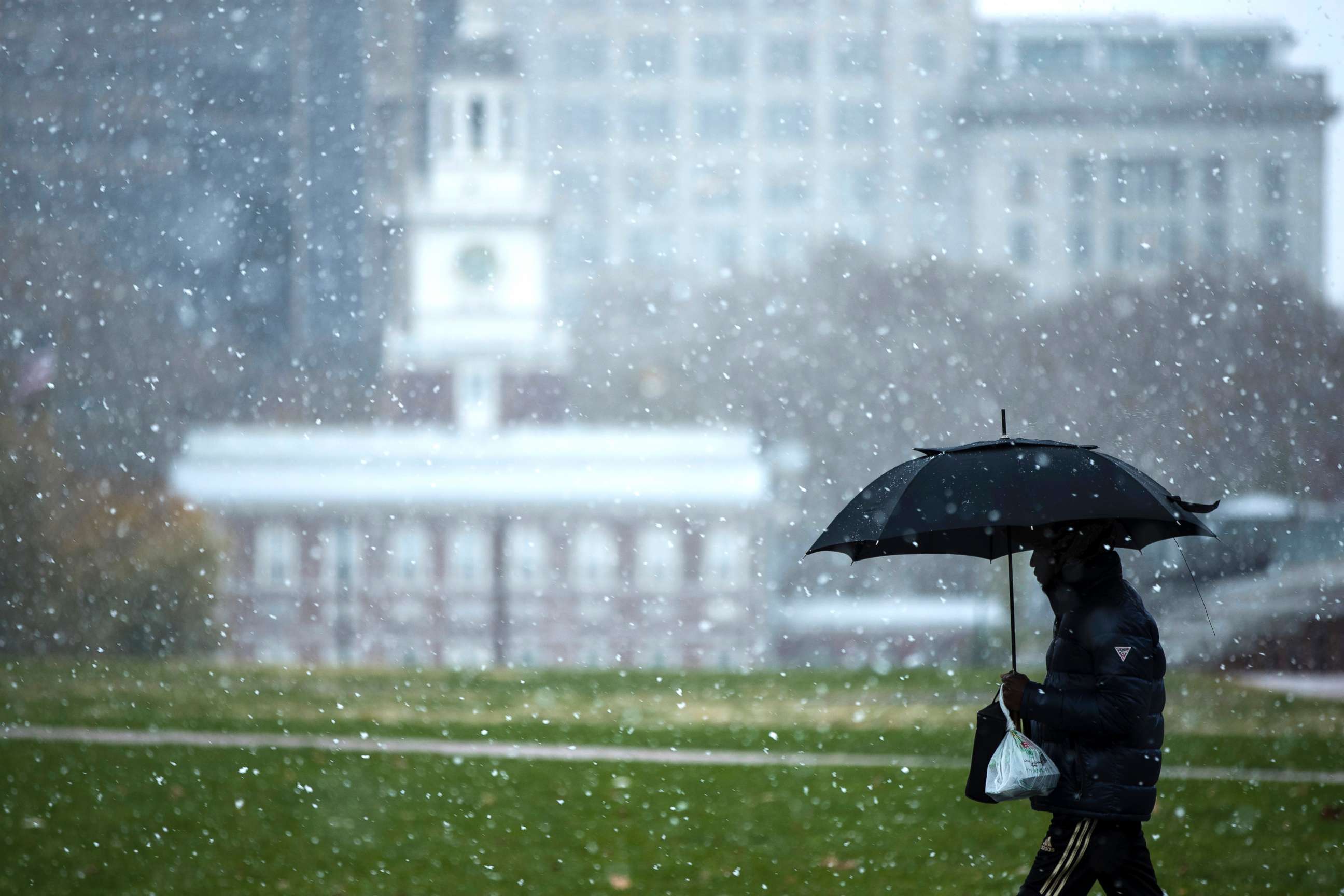 PHOTO: A person walks in view of Independence Hall as snow falls in Philadelphia, Nov. 15, 2018.