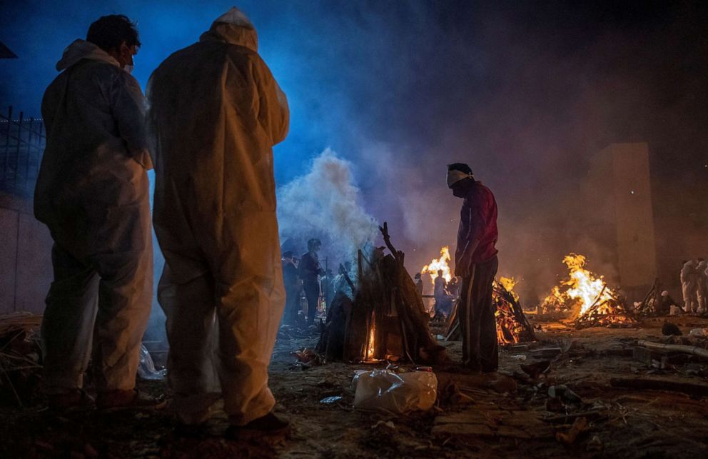 PHOTO: People cremate the body of a COVID-19 victim at a crematorium ground in New Delhi, April 24, 2021. 