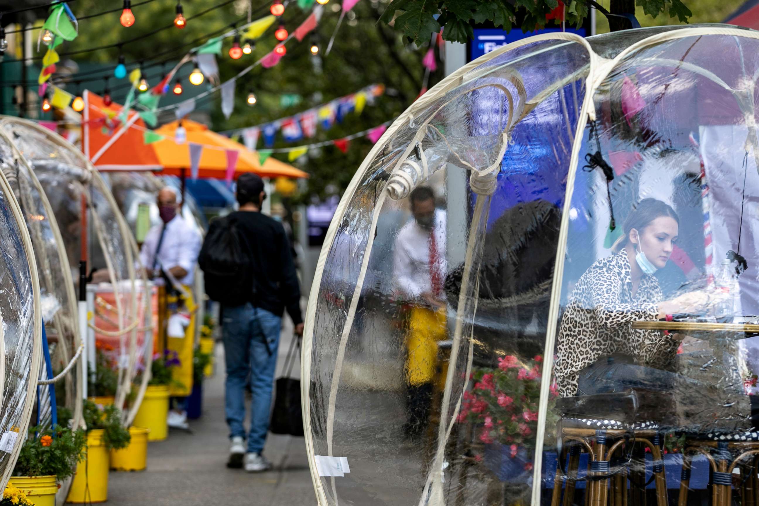 FILE PHOTO: A woman sits outside Cafe Du Soleil under bubble tents used during the novel coronavirus pandemic in Manhattan, New York City, on Sept. 23, 2020.