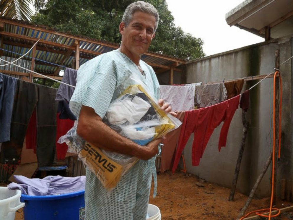 PHOTO: Dr. Besser dons scrubs before putting on several layers of protective gear.