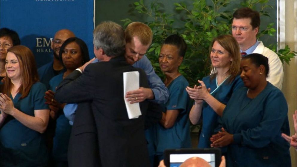PHOTO: Dr. Kent Brantly hugs the staff at Emory Hospital after speaking at a press conference