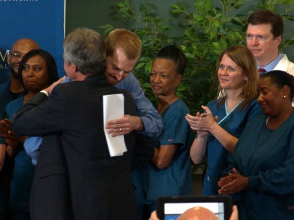 PHOTO: Dr. Kent Brantly hugs the staff at Emory Hospital after speaking at a press conference