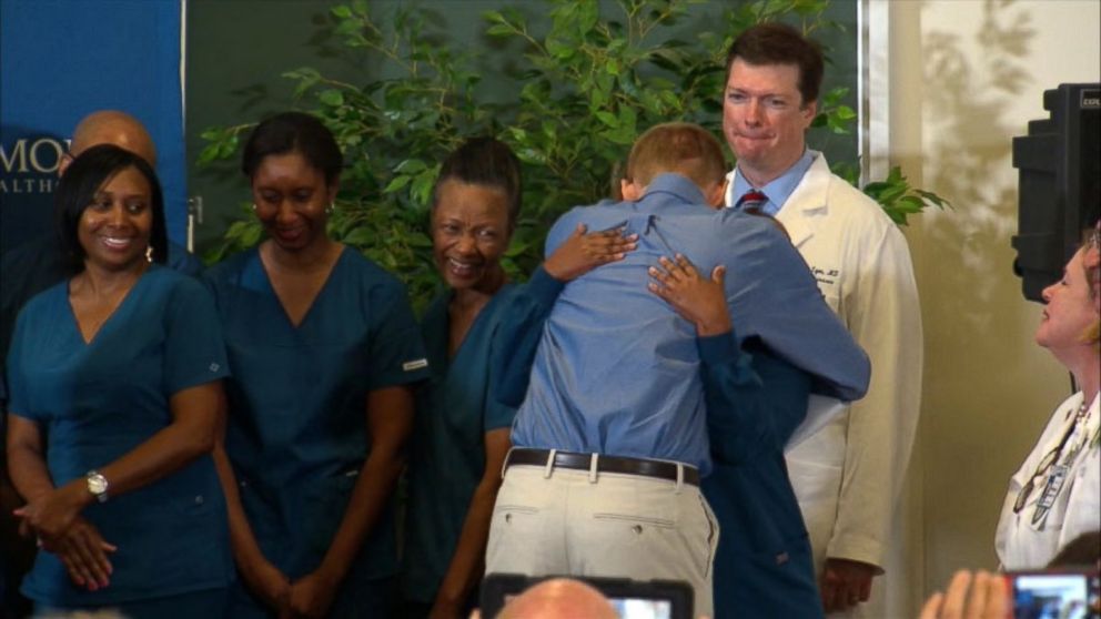 PHOTO: Dr. Kent Brantly hugs the staff at Emory Hospital after speaking at a press conference