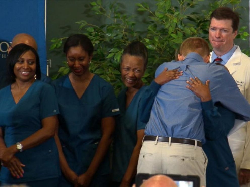 PHOTO: Dr. Kent Brantly hugs the staff at Emory Hospital after speaking at a press conference