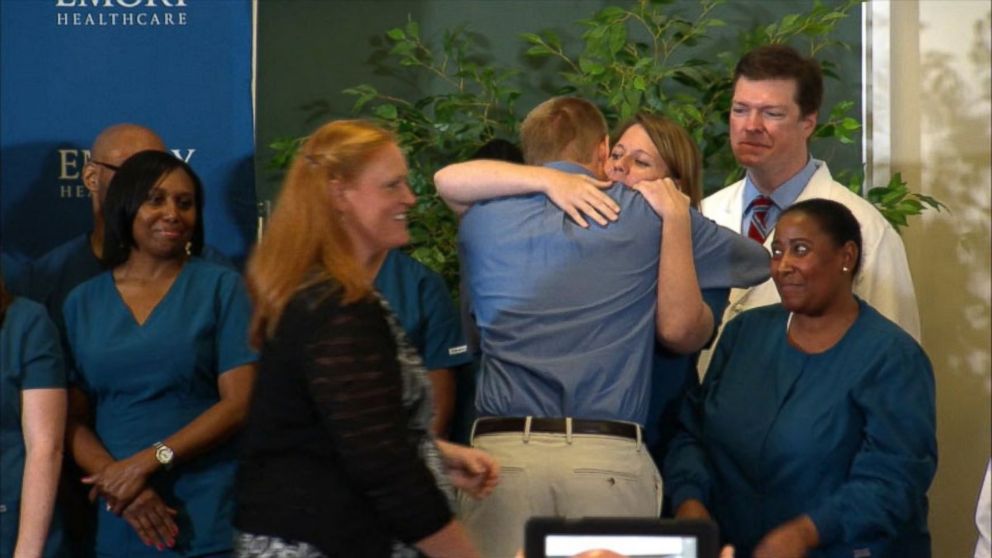 PHOTO: Dr. Kent Brantly hugs the staff at Emory Hospital after speaking at a press conference