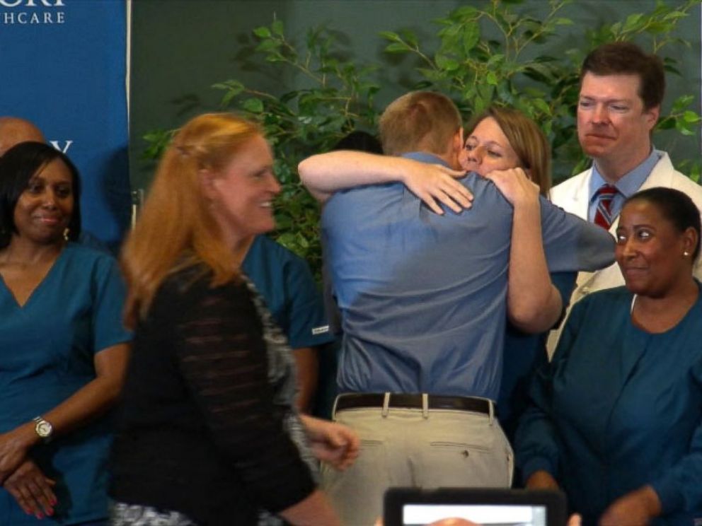PHOTO: Dr. Kent Brantly hugs the staff at Emory Hospital after speaking at a press conference