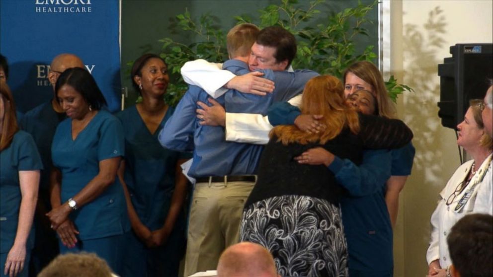 PHOTO: Dr. Kent Brantly hugs the staff at Emory Hospital after speaking at a press conference