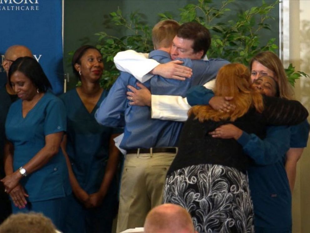 PHOTO: Dr. Kent Brantly hugs the staff at Emory Hospital after speaking at a press conference