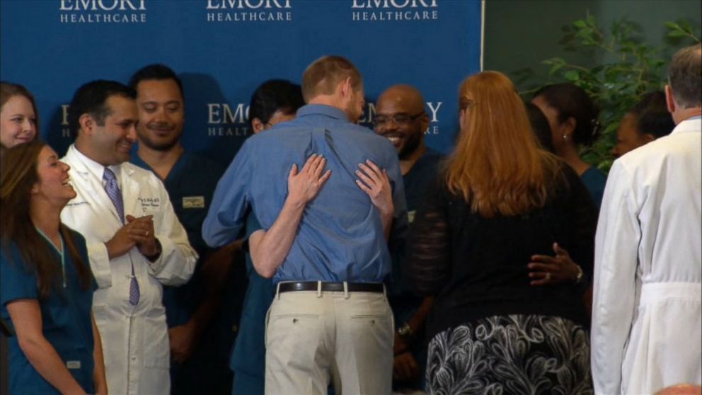 PHOTO: Dr. Kent Brantly hugs the staff at Emory Hospital after speaking at a press conference