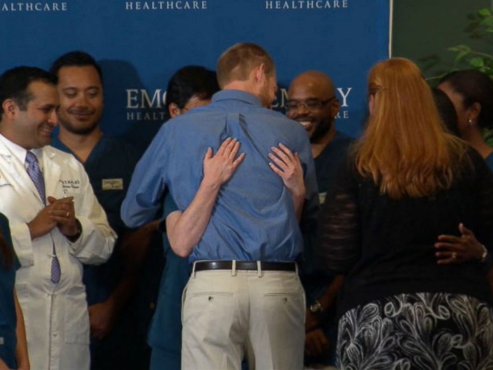 PHOTO: Dr. Kent Brantly hugs the staff at Emory Hospital after speaking at a press conference