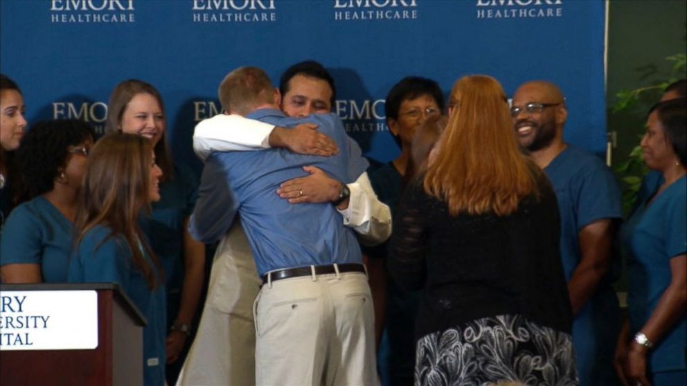 PHOTO: Dr. Kent Brantly hugs the staff at Emory Hospital after speaking at a press conference