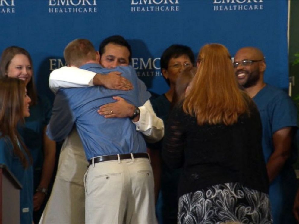 PHOTO: Dr. Kent Brantly hugs the staff at Emory Hospital after speaking at a press conference