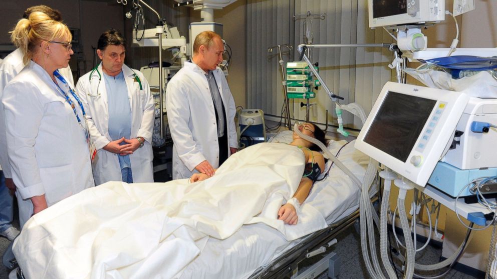 Russian President Vladimir Putin, center, speaks to skier Maria Komissarova in a hospital in Krasnaya Polyana, Russia on Feb. 15, 2014. 