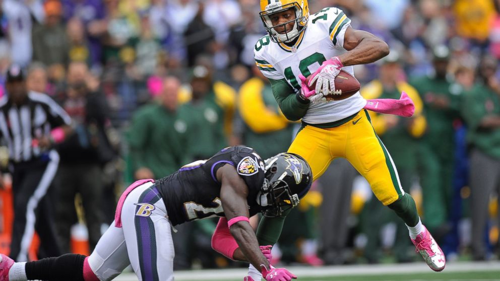 Green Bay Packers wide receiver Randall Cobb, right, takes a hit to the knee in a tackle by Baltimore Ravens free safety Matt Elam during the first half of an NFL football game in Baltimore, Oct. 13, 2013. 
