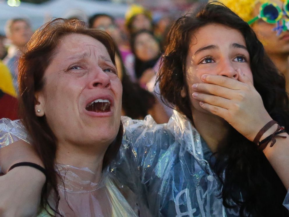 PHOTO: Brazil soccer fans cry as they watch their team lose 7-1 to Germany at a World Cup semifinal match on a live telecast inside the FIFA Fan Fest area on Copacabana beach in Rio de Janeiro, Brazil on July 8, 2014. 
