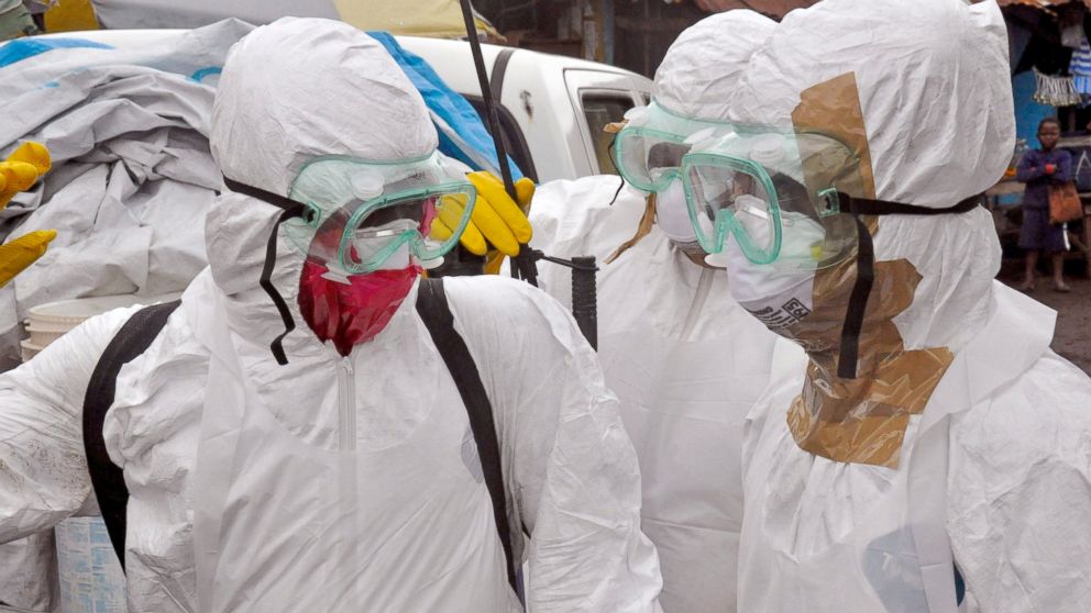 Health workers in protective gear leave after carrying the body of a woman that they suspect died from the Ebola virus, in an area known as Clara Town in Monrovia, Liberia, Sept. 10, 2014. 