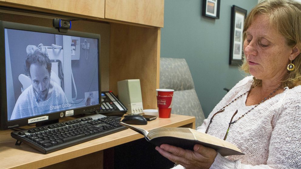PHOTO: In this Sept. 10, 2014 photo released by the Nebraska Medical Center, Debbie Sacra reads Bible verses to her husband Dr. Richard Sacra via a video link in Omaha, Neb.