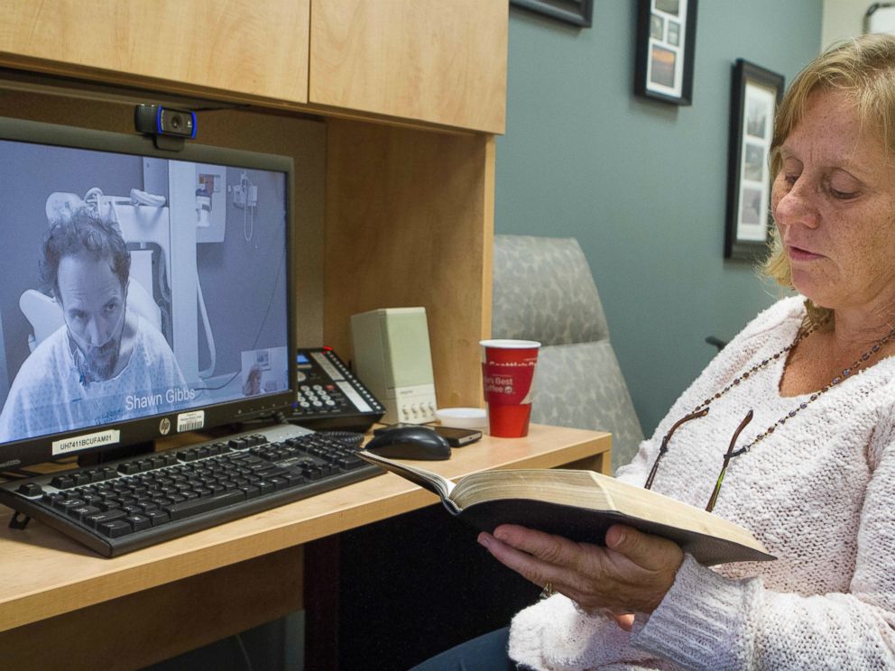PHOTO: In this Sept. 10, 2014 photo released by the Nebraska Medical Center, Debbie Sacra reads Bible verses to her husband Dr. Richard Sacra via a video link in Omaha, Neb.