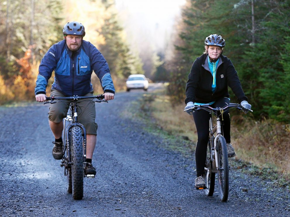 PHOTO: Nurse Kaci Hickox, right, and her boyfriend, Ted Wilbur are followed by a Maine State Trooper as they ride bikes on a trail near her home in Fort Kent, Maine, Oct. 30, 2014.