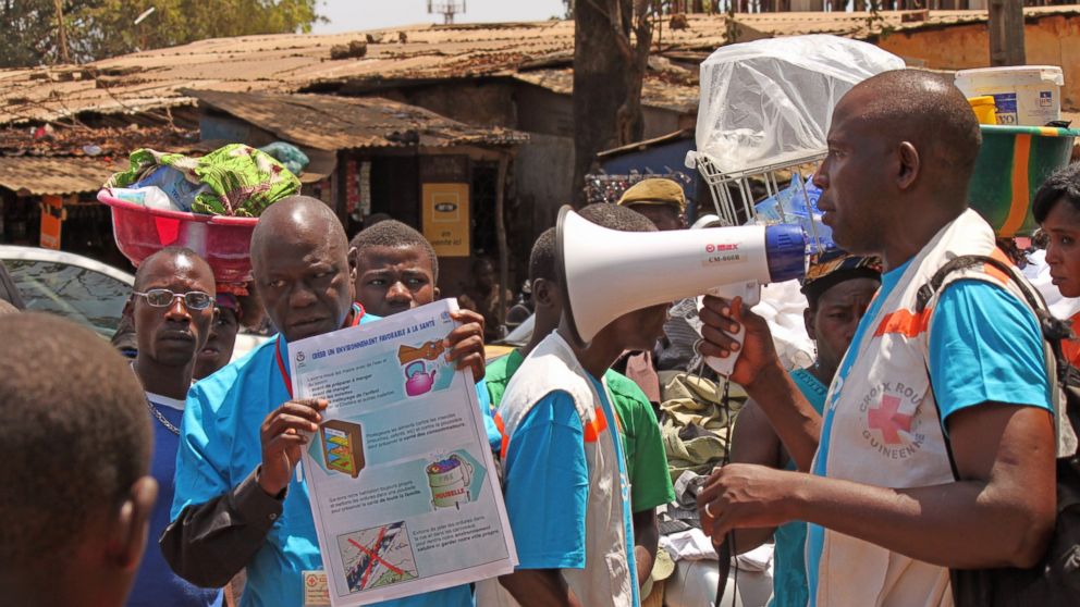 Health workers teach people about the Ebola virus and how to prevent infection, in Conakry, Guinea, March 31, 2014.