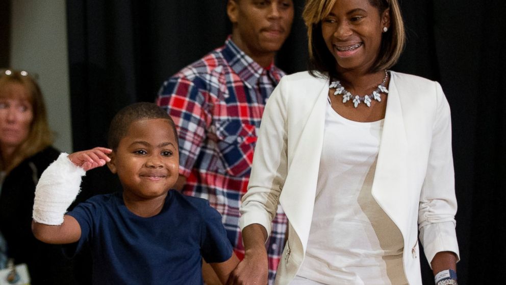 Double-hand transplant recipient, eight-year-old Zion Harvey, arrives to a news conference with his mother Pattie Ray on July 28, 2015 in Philadelphia. 