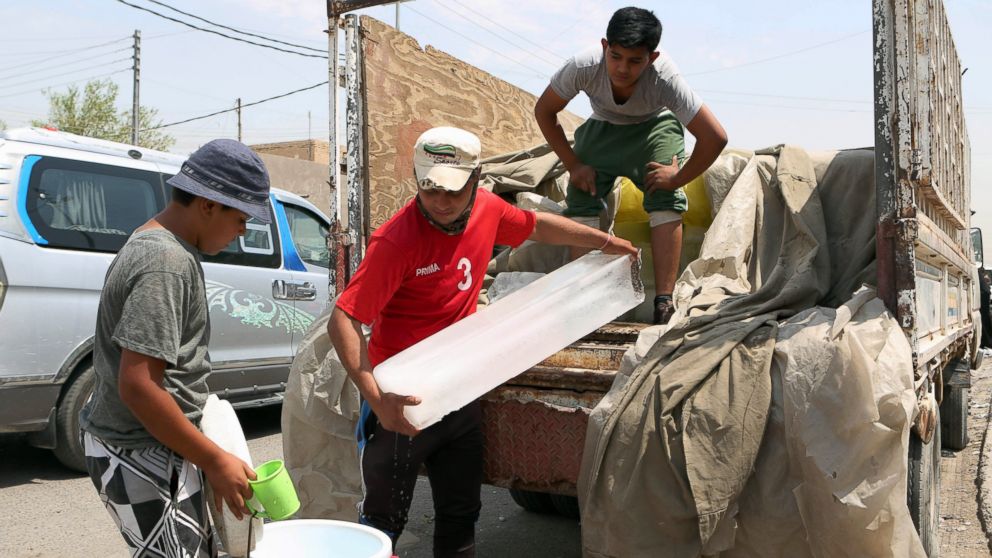 People buy blocks of ice in Basra, southeast of Baghdad, Iraq, July 30, 2015 due to the unprecedented heat wave.