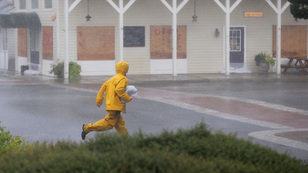 PHOTO: A crew member of the tall ship Peacemaker runs past boarded up buildings as Hurricane Matthew begins to hit the area, Oct. 7, 2016, in Saint Mary's, Georgia. 