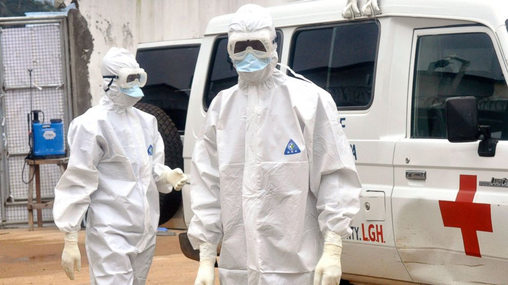 PHOTO: Health workers wearing protective gear wait to carry the body of a person suspected to have died from Ebola, in Monrovia, Liberia, Oct. 13, 2014.
