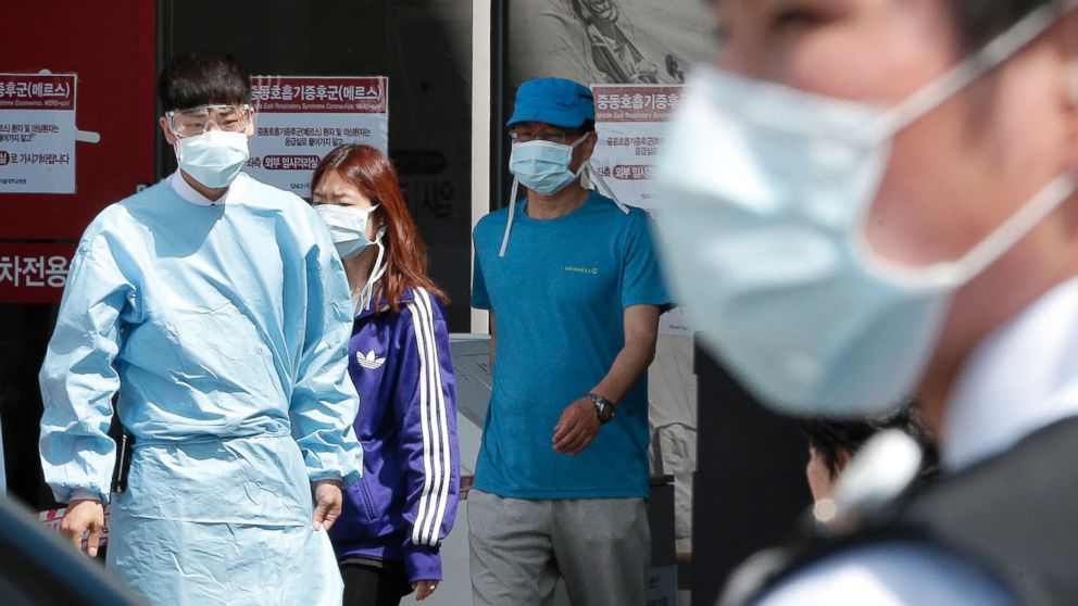 Hospital workers and visitors wearing masks pass by a precaution against the MERS, Middle East Respiratory Syndrome, virus at a quarantine tent for people who could be infected with the virus at Seoul National University Hospital in Seoul, June 3, 2015. 