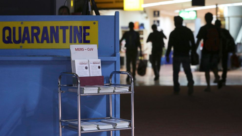 PHOTO: Passengers walk past the medical quarantine area showing information sheets for the Middle East respiratory syndrome coronavirus at the arrival section of Manila's International Airport in Paranaque, south of Manila, Wednesday, April 16, 2014. 