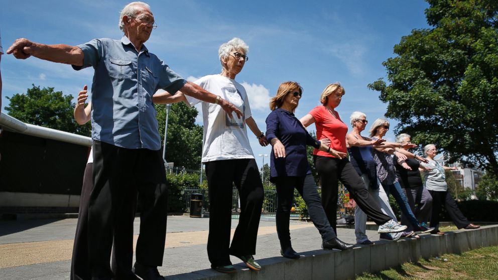 85-year-old George Jackson, left, an army veteran and former boxer, 79-year-old Lara Thomson, 2nd left, and others participate at a parkour class for elderly people at a park in London, England on June 17, 2014.