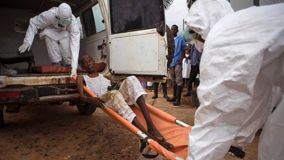 Healthcare workers load a man, center, onto a ambulance as he is suspected of suffering from the Ebola virus in Kenema, Sierra Leone, Sept. 24, 2014. 