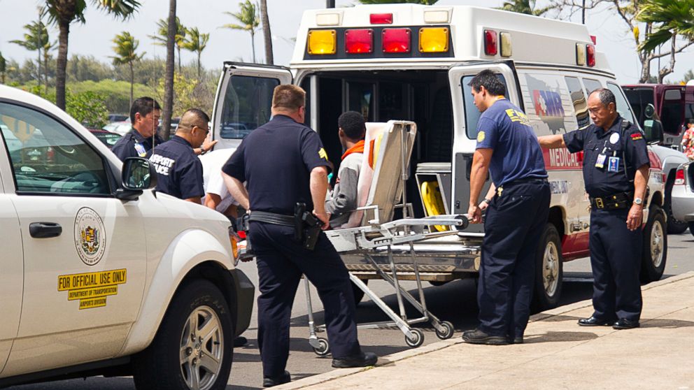 A 15-year-old boy, seen sitting on a stretcher center, who stowed away in the wheel well of a flight from San Jose, Calif., to Maui is loaded into an ambulance at Kahului Airport in Kahului, Maui, Hawaii, April, 20, 2014.