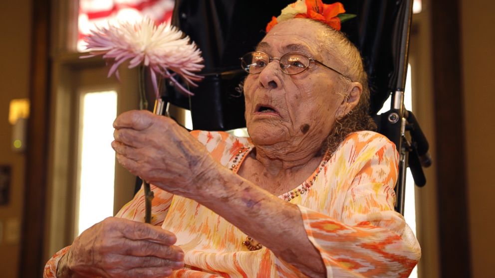 Gertrude Weaver holds a flower given to her a day before her 116th birthday, at Silver Oaks Health and Rehabilitation Center in Camden, Ark. on July 3, 2014. 