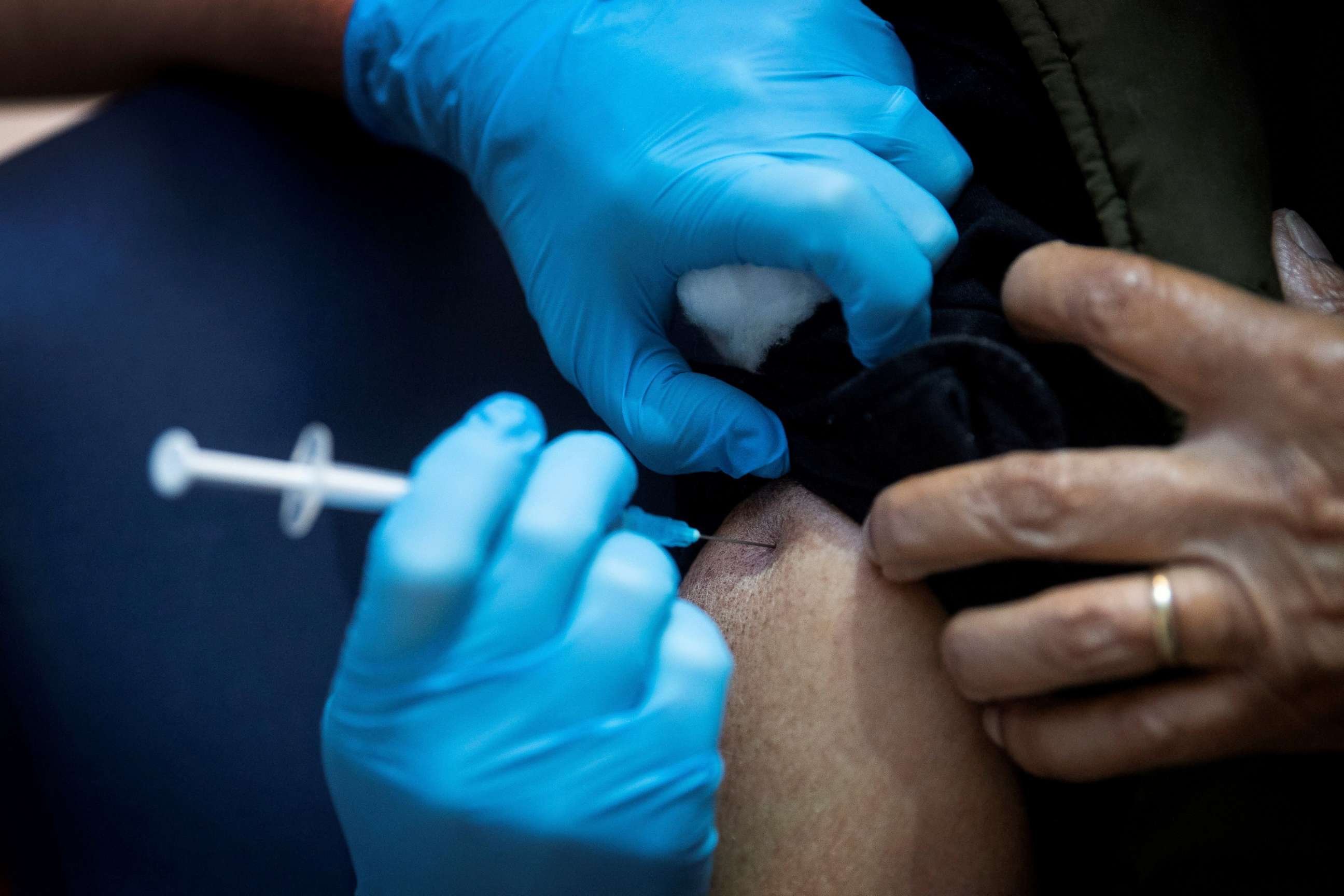 FILE PHOTO: A man receives the first of two Pfizer/BioNTech COVID-19 vaccine jabs, at Guy's Hospital in London, Britain, Dec. 8, 2020.