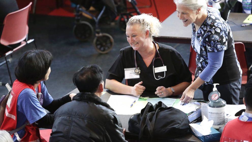 Nursing student Coral Janisse (2R) checks in patients as people get free dental, vision and medical care during the Seattle/King County Clinic at the Key Arena in Seattle, on Oct. 28, 2016. 