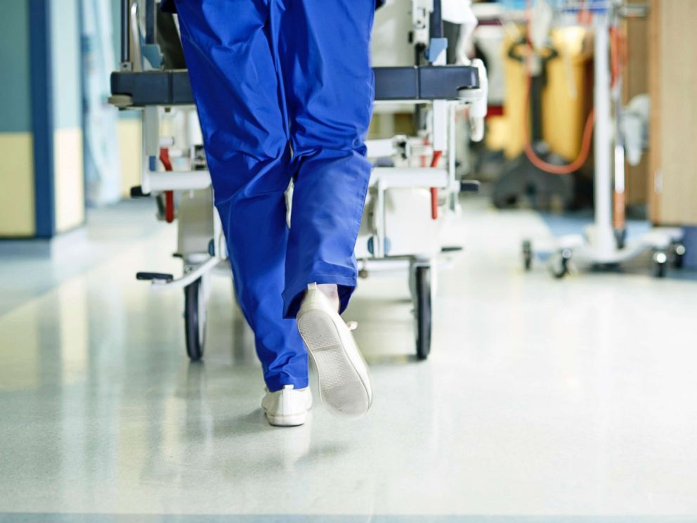 PHOTO: A medic runs with a gurney along a hospital corridor.
