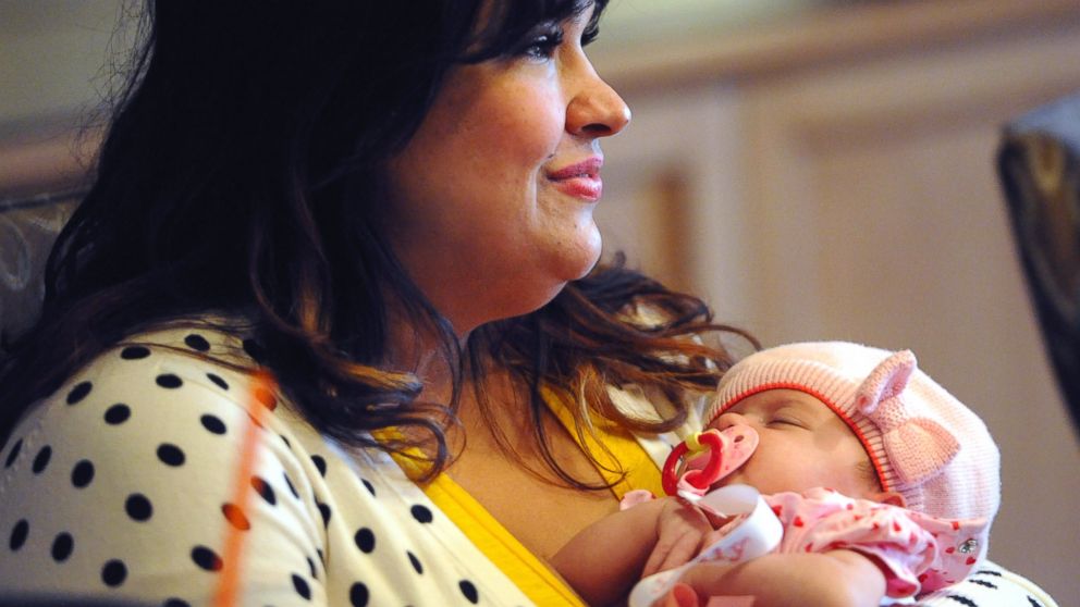 Ruby Graupera-Cassimiro of Deerfield Beach, Fla., holds her newborn daughter, Taily, Nov, 4, 2014, as she describes her near-death experience after undergoing a scheduled C-section in Sept. 2014.