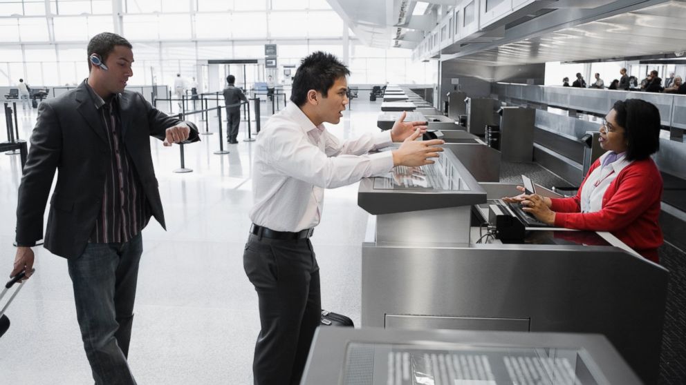 Businessman shouting at an airline check-in attendant in this undated photo.