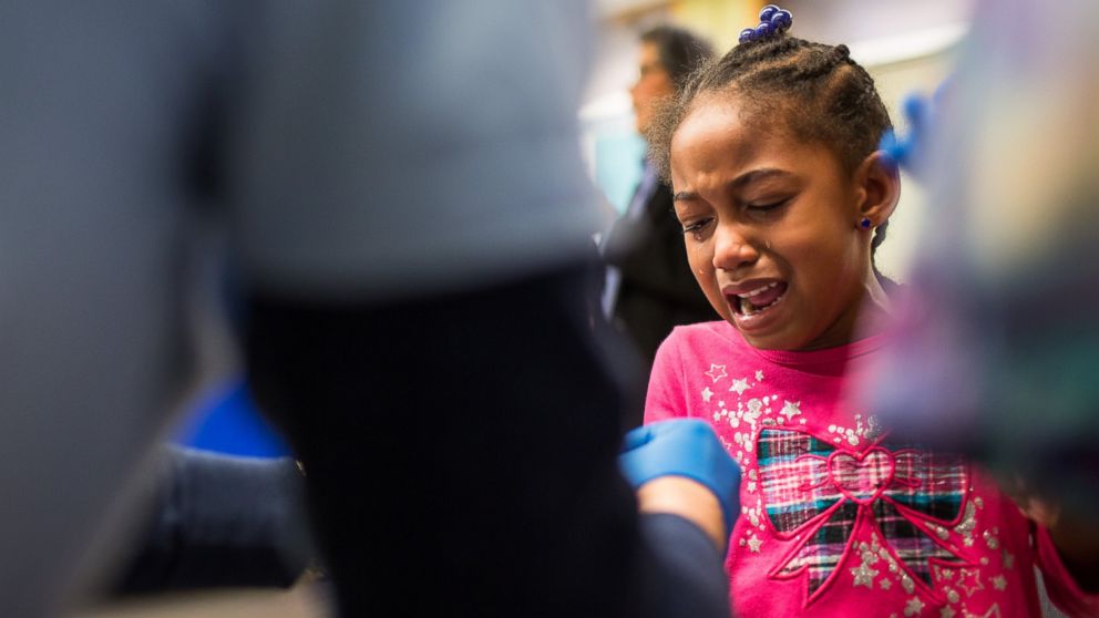 Tears stream down the face of Morgan Walker, age 5 of Flint, as she gets her finger pricked for a lead screening on Jan. 26, 2016 at Eisenhower Elementary School in Flint, Mich.  