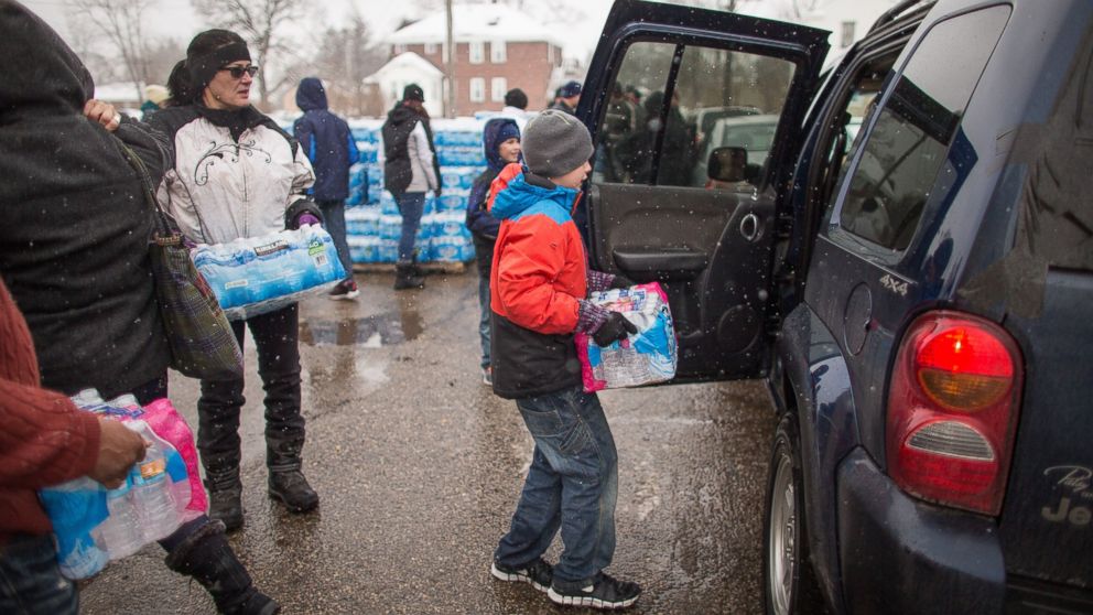 PHOTO: Volunteers load cases of free water into waiting vehicles at a water distribution centre at Salem Lutheran Church in Flint, Mich., on March 5, 2016.
