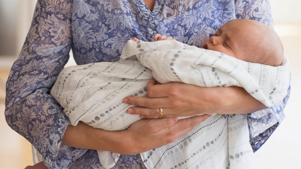A mother holds her baby in this stock image. Measles cases in the current California outbreak top 90. 