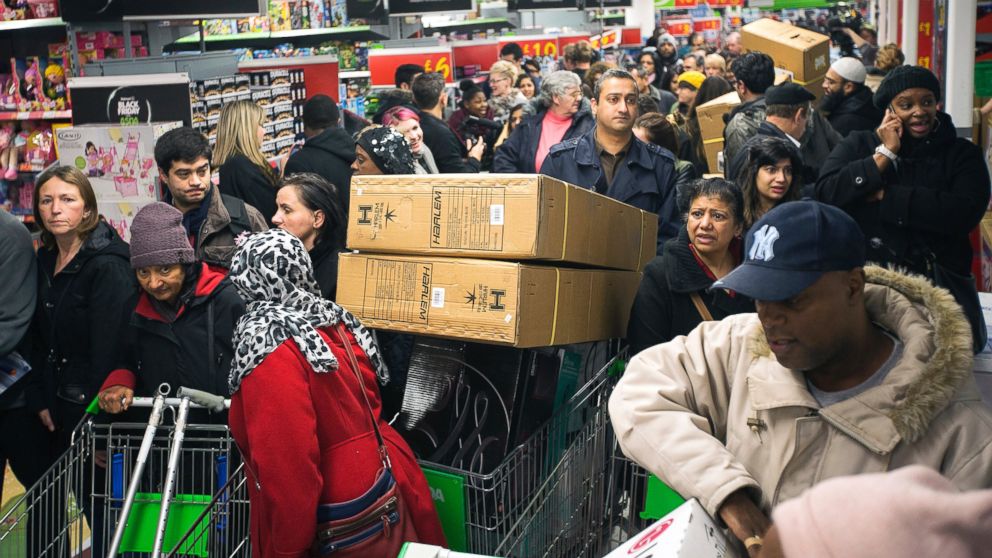 Customers push loaded shopping carts through crowded aisles as they look for bargains during a Black Friday discount sale inside an Asda supermarket in Wembley, London, Nov. 29, 2013.