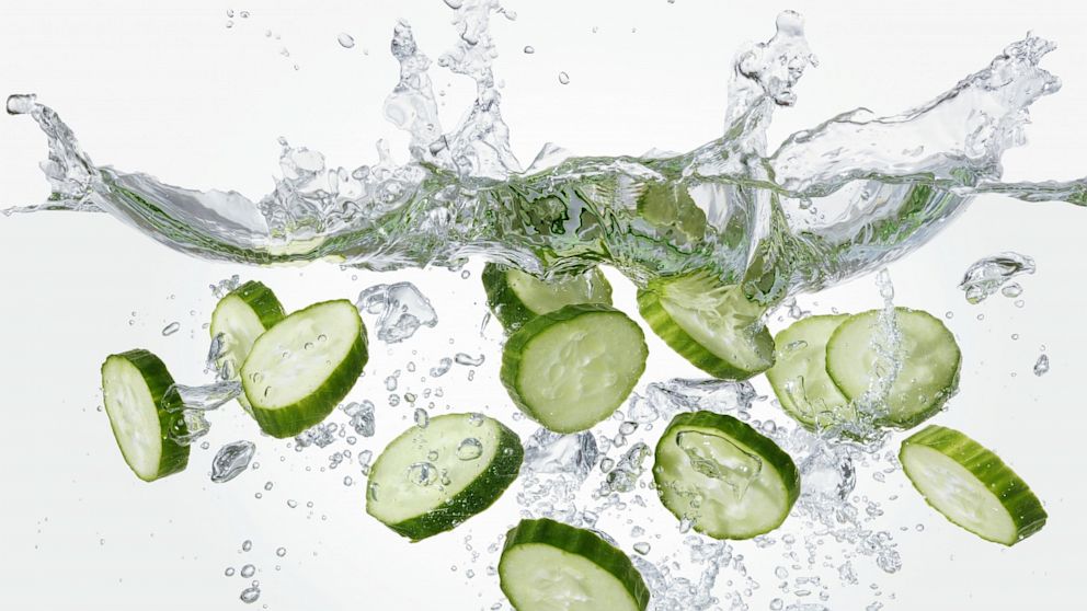 Slices of cucumber falling into water.