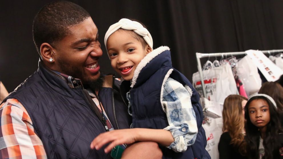 NFL player Devon Still, left, and his daughter prepare backstage at the Nike Levi's Kids fashion show during Mercedes-Benz Fashion Week Fall 2015 at The Salon at Lincoln Center, Feb. 12, 2015, in New York. 
