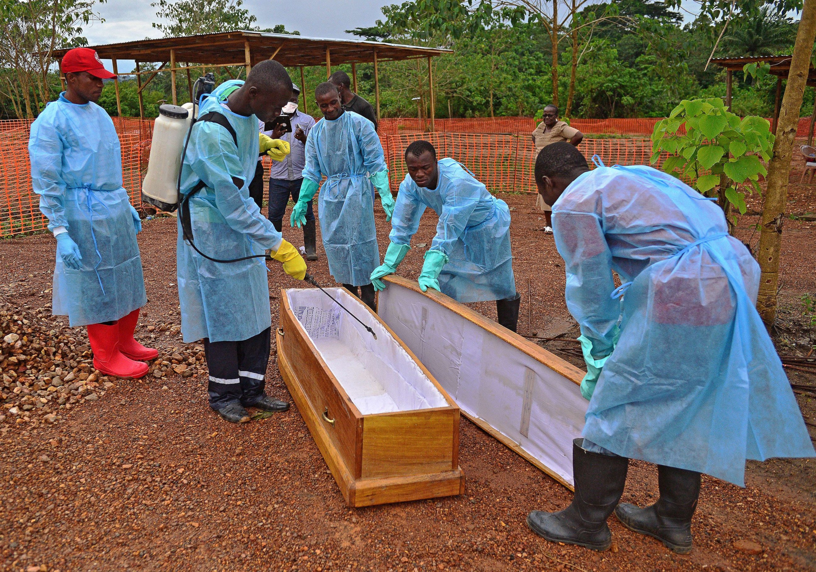 PHOTO: Sierra Leonese government burial team members are pictured wearing protective clothing while disinfecting a coffin at the Medecins Sans Frontieres facility in Kailahun, Sierra Leone on Aug. 14, 2014. 