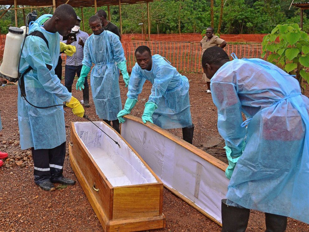 PHOTO: Sierra Leonese government burial team members are pictured wearing protective clothing while disinfecting a coffin at the Medecins Sans Frontieres facility in Kailahun, Sierra Leone on Aug. 14, 2014.